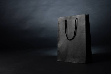 Gri arka planda gri kağıt alışveriş torbası kompozisyonu. Perakende, alışveriş ve Kara Cuma konsepti.