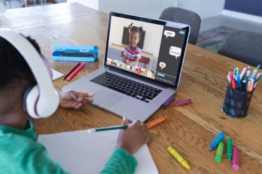 Ekranda gülümseyen ilkokul öğrencisiyle video görüşmesi için dizüstü bilgisayar kullanan Afrikalı Amerikalı çocuk. iletişim teknolojisi ve çevrimiçi eğitim, dijital kompozit resim.