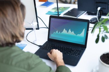 Masasında oturan beyaz iş kadını, ekranında istatistiksel veriler olan bir dizüstü bilgisayar kullanıyor. iş iletişimi ve dijital arayüz teknolojisi dijital kompozit görüntü.