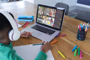 Ekranda farklı ilkokul öğrencileri olan Afro-Amerikan çocuk, video görüşmesi için dizüstü bilgisayar kullanıyor. iletişim teknolojisi ve çevrimiçi eğitim, dijital kompozit resim.