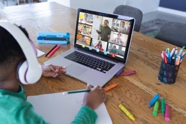Ekranda farklı ilkokul öğrencileri olan Afro-Amerikan çocuk, video görüşmesi için dizüstü bilgisayar kullanıyor. iletişim teknolojisi ve çevrimiçi eğitim, dijital kompozit resim.