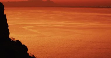 Kayalık sahilde gün batımının güzel bir görüntüsü. Doğada huzur ve güzellik, manzara manzarası.