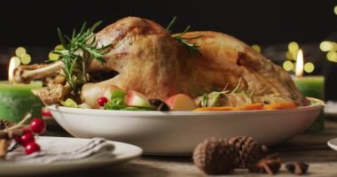 Tepside pişmiş hindi ve ahşap yüzeyde çeşitli tabaklar var. Şükran Günü, Amerikan kültürü, gelenek ve kutlama videosu.