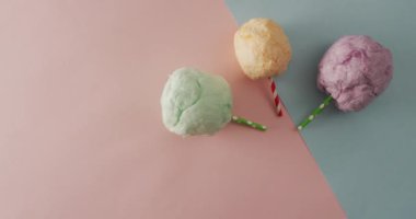 Çubukların üzerinde pembe ve yeşil pastel yüzeyde duran şekerlemelerin videosu. Yemek, yemek, tatlı, mutfak ve yemek pişirme konsepti.