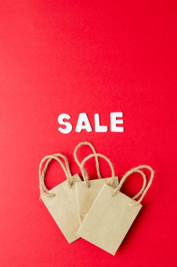 Satış metni ve pembe arka planda kağıt alışveriş torbaları. Perakende, alışveriş ve Kara Cuma konsepti.