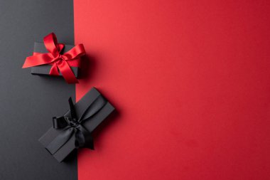 Gri ve pembe arka planda pembe ve siyah kurdeleli hediyelerin kompozisyonu. Perakende, alışveriş ve Kara Cuma konsepti.