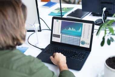 Masada oturan beyaz iş kadını ekranda istatistiksel verileri olan bir dizüstü bilgisayar kullanıyor. iş iletişimi ve dijital arayüz teknolojisi dijital kompozit görüntü.
