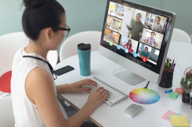 Asyalı kız ekranda çeşitli ilköğretim öğrencileri gülümserken görüntülü konuşma için bilgisayar kullanıyor. iletişim teknolojisi ve çevrimiçi eğitim, dijital kompozit resim.