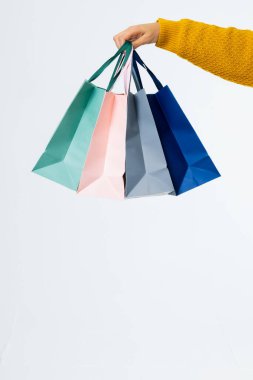 Beyaz arka planda alışveriş torbaları olan el kompozisyonu. Perakende, alışveriş ve Kara Cuma konsepti.