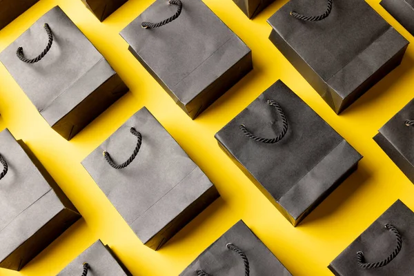 黄色の背景にグレーの紙のショッピングバッグの組成 ショッピング 黒の金曜日のコンセプト — ストック写真