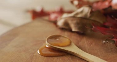Ahşap kaşık üzerinde sonbahar yapraklı akçaağaç şurubu videosu. Amerikan mutfağı, yemek, yemek ve yemek konsepti.