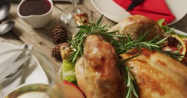 Tepside pişmiş hindi ve ahşap yüzeyde çeşitli tabaklar var. Şükran Günü, Amerikan kültürü, gelenek ve kutlama videosu.