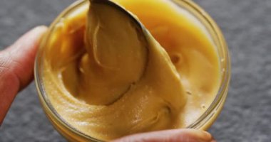 Gri arka planda fıstık ezmeli yakın çekim videosu. Yiyecek, parti ve fotokopi alanı.