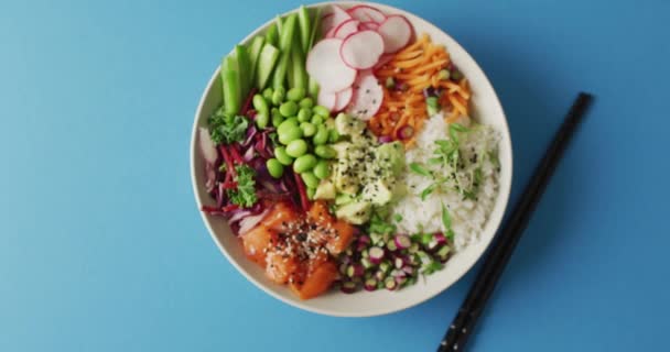 Composición Tazón Arroz Salmón Verduras Con Palillos Sobre Fondo Azul — Vídeos de Stock