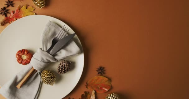 有餐具的盘子和橙色表面有叶子的秋天装饰的视频 感恩节 美国文化 传统和庆祝视频 — 图库视频影像