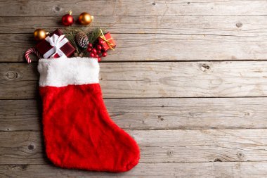 Yılbaşı çorabındaki noel süslemeleri ve ahşap arka plandaki boşluğun kopyası. Noel, gelenek ve kutlama konsepti.