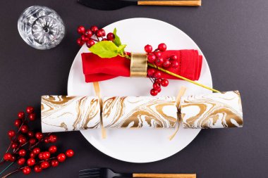 Gri arka planda çatal bıçak takımı ve kraker süslemesi olan noel mekanının resmi. Noel, gelenek ve kutlama konsepti.