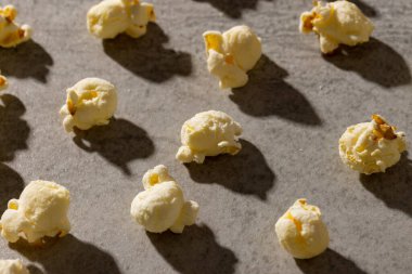 Gri arkaplanda patlamış mısır resmi. Yiyecek, atıştırmalık, sinema ve Amerikan mutfağı konsepti.