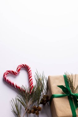 Noel bastonları, hediyeler, Noel ağacı dalları ve beyaz arka planda süslemeler. Noel, gelenek ve kutlama konsepti.
