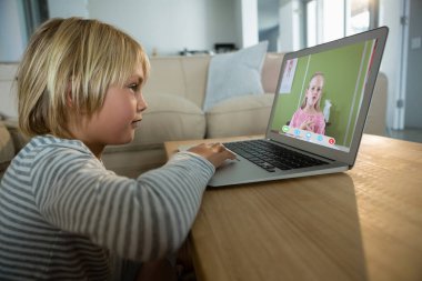 Ekranda ilkokul öğrencisiyle video görüşmesi için dizüstü bilgisayar kullanan beyaz çocuk. iletişim teknolojisi ve çevrimiçi eğitim, dijital kompozit resim.