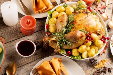 Şükran Günü masasının üstünde hindi, sebze, mum ve sonbahar süslemeleri var. Şükran Günü, Sonbahar, Sonbahar, Amerikan geleneği ve kutlama konsepti.