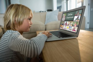 Beyaz çocuk ekranda çeşitli ilköğretim öğrencileri gülümserken görüntülü konuşma için laptop kullanıyor. iletişim teknolojisi ve çevrimiçi eğitim, dijital kompozit resim.