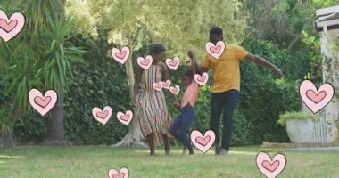 Bahçedeki mutlu Afro-Amerikan ailesi yerine kalp animasyonu. Aile hayatı, aşk ve doğa konsepti dijital olarak oluşturulmuş video.