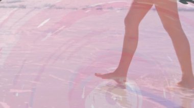 Pembe daireler üzerinde deniz kenarında yürüyen beyaz kadın animasyonu. Seyahat, tatil ve boş zaman konsepti dijital olarak oluşturulmuş video.