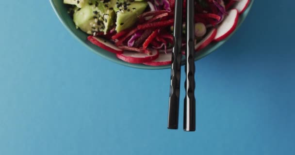 Sammansättning Skål Med Ris Och Grönsaker Med Ätpinnar Blå Bakgrund — Stockvideo