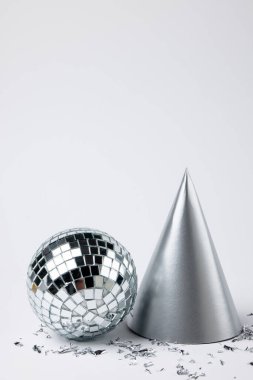 Beyaz arka planda yeni yıl şapkası ve konfeti kompozisyonu. Yeni yıl partisi, kutlama ve uzay konseptini kopyalama.