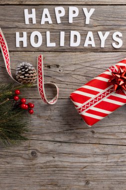Yılbaşı metni ve süslemesi, hediye, çam kozalakları ve tahta arka planda fotokopi alanı. Noel, gelenek ve kutlama konsepti.