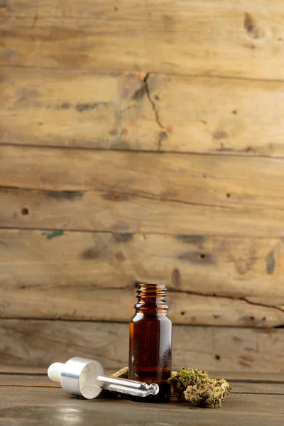 Вертикальное Изображение Бутылки Масла Cbd Сушеных Листьев Марихуаны Деревянной Поверхности — стоковое фото