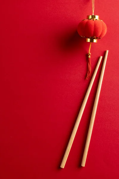 Composition of traditional chinese decorations and chopsticks on red background. Chinese new year, tradition and celebration concept.