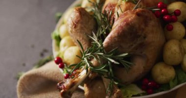 Tepside pişmiş hindi, patates ve biberli gri yüzey. Şükran Günü, Amerikan kültürü, gelenek ve kutlama videosu.