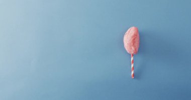 Çubuğun üzerinde mavi yüzeyde duran şekerlemenin videosu. Yemek, yemek, tatlı, mutfak ve yemek pişirme konsepti.