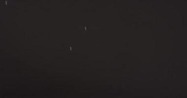 Gece gökyüzü arka planında parlayan beyaz karın videosu. Noel, gelenek ve kutlama konsepti.