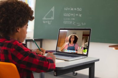 Ekranda ilkokul öğrencisiyle video görüşmesi için dizüstü bilgisayar kullanan Afrikalı Amerikalı çocuk. iletişim teknolojisi ve çevrimiçi eğitim, dijital kompozit resim.