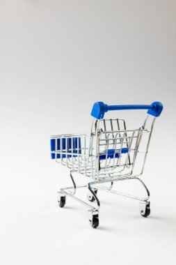 Alışveriş arabasının kompozisyonu ve beyaz arka planda fotokopi alanı. Perakende, alışveriş ve Kara Cuma konsepti.