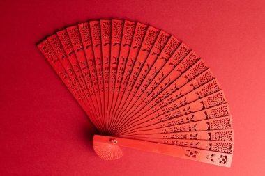 Kırmızı arka planda geleneksel Çin fanı kompozisyonu. Çin yeni yılı, gelenek ve kutlama konsepti.