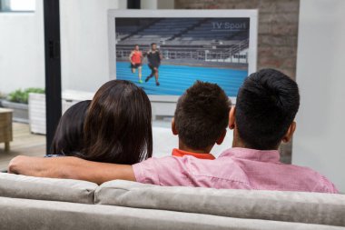 Mutlu aile kanepede televizyon izlerken arka görünümü