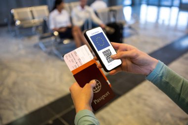 Elinde belgeler ve kovanlı 19 aşılı pasaportlu akıllı telefon olan bir kadın. küresel covid 19 salgın konsepti dijital olarak oluşturulmuş video.