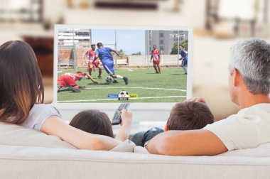 Futbol oyuncular tacakling için sahada top karşı birlikte televizyon izlerken kanepede oturan aile