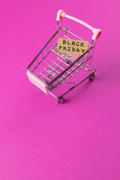 ピンクの背景に黒い金曜日のテキストとショッピングカートの構成 ショッピング 黒の金曜日のコンセプト — ストック写真