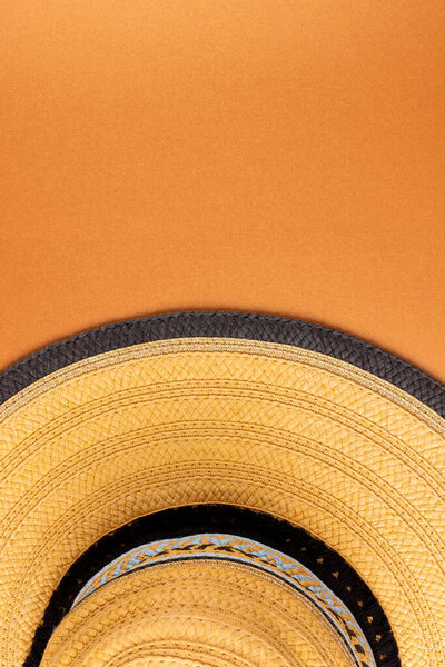 Vertical image of straw hat on yellow surface. Clothes, textiles, fashion, style and outfit concept.