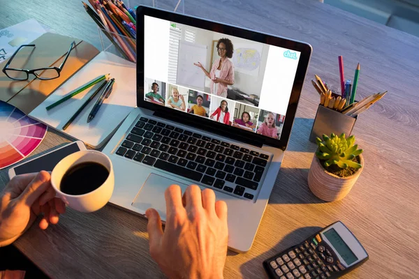 Hands of man using laptop for video call, with smiling diverse elementary school pupils on screen. communication technology and online education, digital composite image.