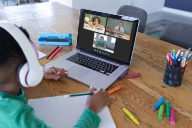 Ekranda farklı ilkokul öğrencileri olan Afro-Amerikan çocuk, video görüşmesi için dizüstü bilgisayar kullanıyor. iletişim teknolojisi ve çevrimiçi eğitim, dijital kompozit resim.