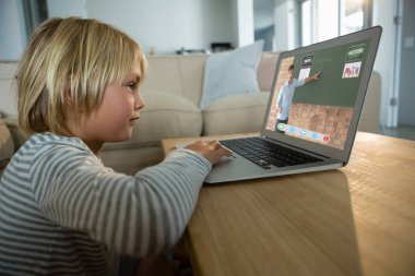 Beyaz çocuk video görüşmesi için dizüstü bilgisayar kullanıyor, ekranda beyaz erkek öğretmen var. iletişim teknolojisi ve çevrimiçi eğitim, dijital kompozit resim.
