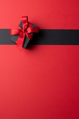 Gri ve pembe arkaplanlı pembe kurdeleli mevcut kompozisyon. Perakende, alışveriş ve Kara Cuma konsepti.