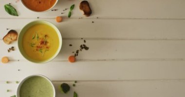 Beyaz yüzeyde bulunan çeşitli kremalı sebze çorbalarının videosu. Amerikan mutfağı, yemek, yemek ve yemek konsepti.