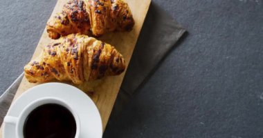 Gri arka planda kruvasanların yakın çekim videosu. Gıda, fırın ve kopyalama alanı kavramı.